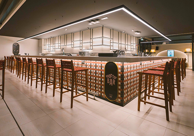 The design establishes a clear hierarchy of light, featuring ambient illumination for comfort and conviviality, accent lighting to highlight key features, and feature lighting that reinforces the Time Out Market brand.